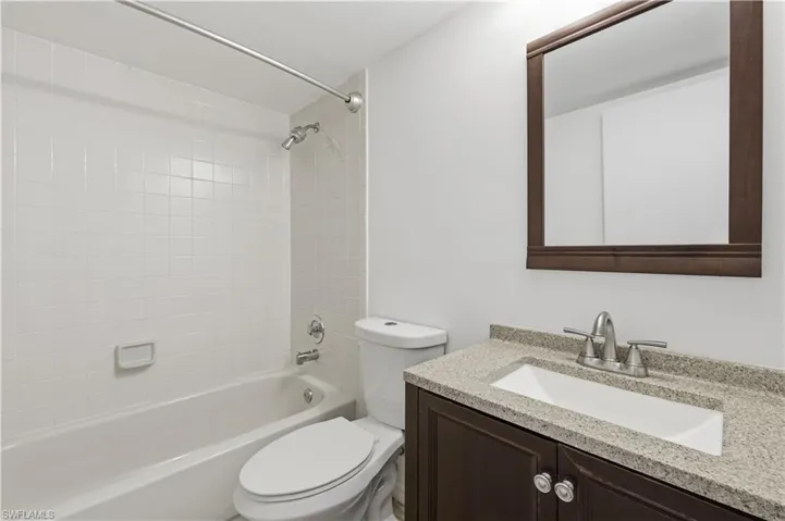 Bathroom featuring a vanity with a light-colored countertop, an undermount sink, and a dark wood-finish cabinet