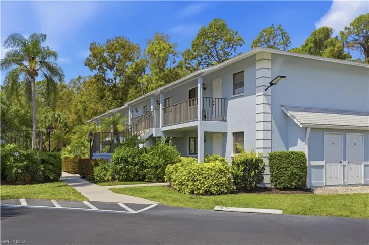 Light blue exterior featuring white trim accents, multiple private balconies, and an attached utility storage area