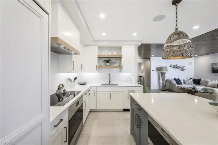 Kitchen with white cabinetry, open shelves, decorative light fixtures, light stone countertops, and recessed lighting