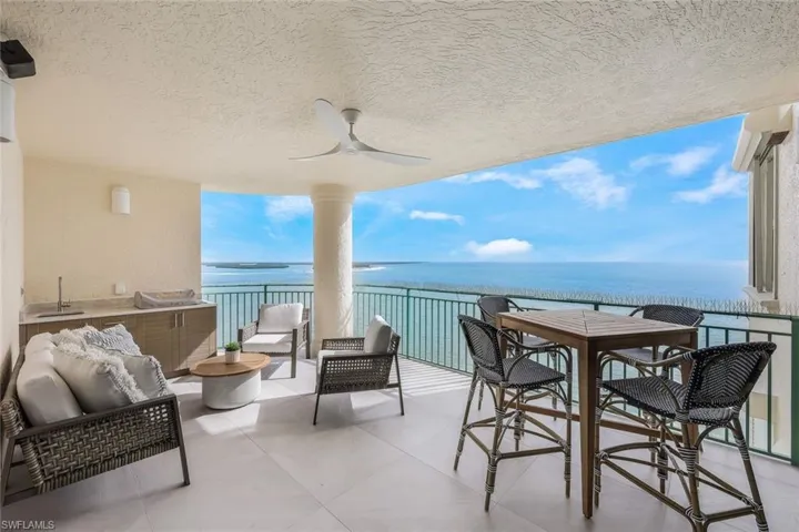Balcony with a ceiling fan, a water view, and outdoor lounge area