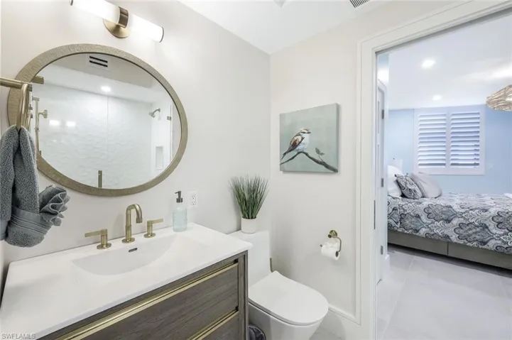 Guest jack and Jill Bathroom featuring light tile patterned flooring, vanity, recessed lighting, a shower stall, and connected bathroom