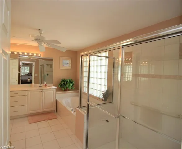 Bathroom featuring vanity, separate shower and tub, ceiling fan, and tile patterned floors