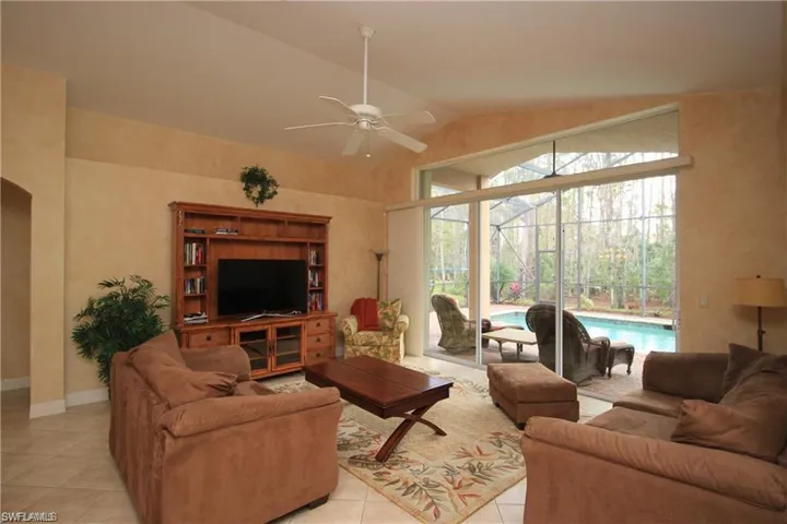 Tiled living room featuring vaulted ceiling and ceiling fan
