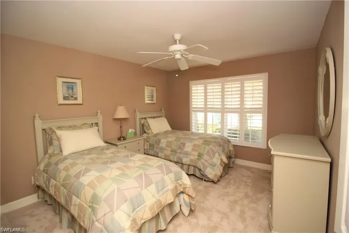 Carpeted bedroom featuring ceiling fan