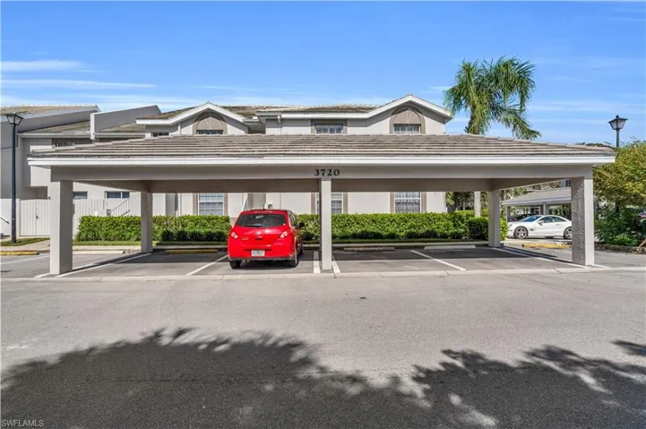 View of parking / parking lot featuring a carport