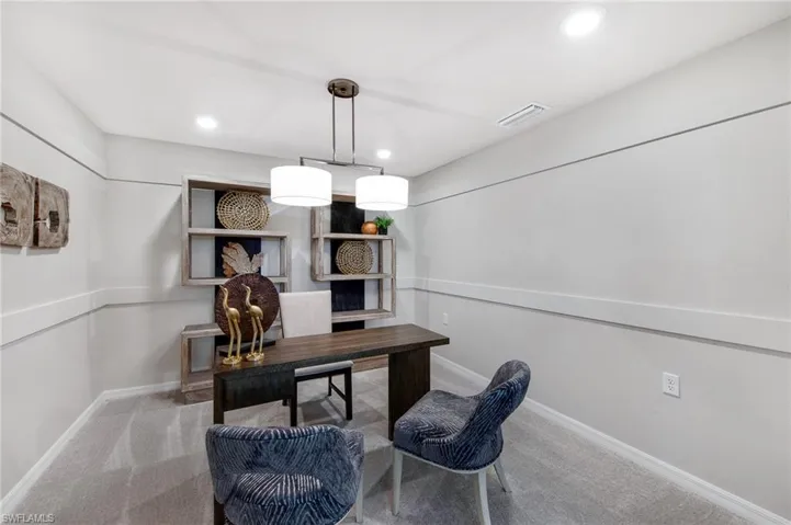 Carpeted office space with recessed lighting and baseboards