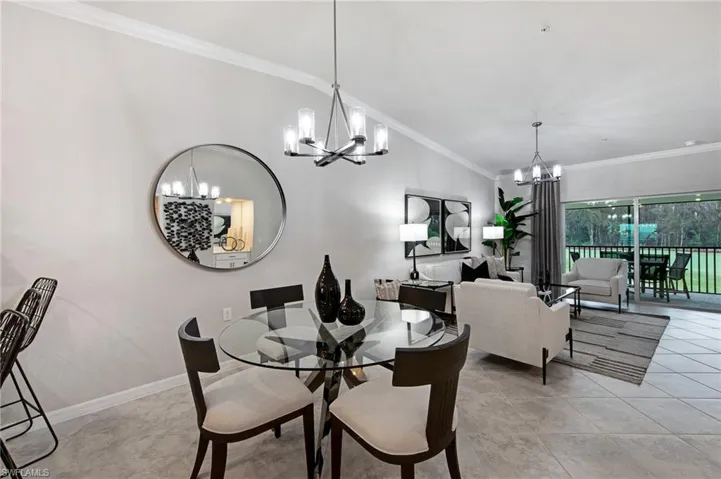 Dining room with crown molding, lofted ceiling, and a chandelier