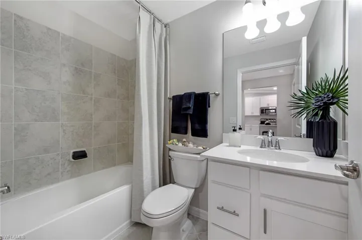 Full bath featuring vanity and shower / bath combination with curtain