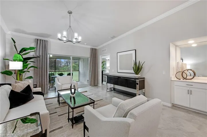 Living area with ornamental molding and a chandelier