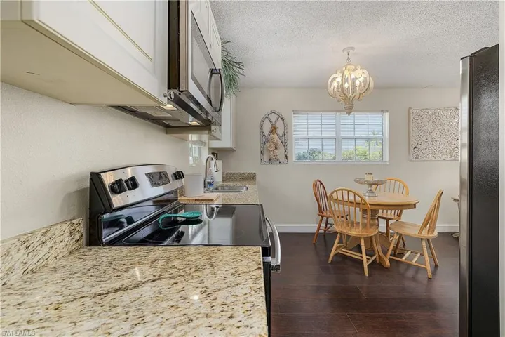 Kitchen featuring sink, dark hardwood / wood-style floors, a textured ceiling, and stainless steel appliances