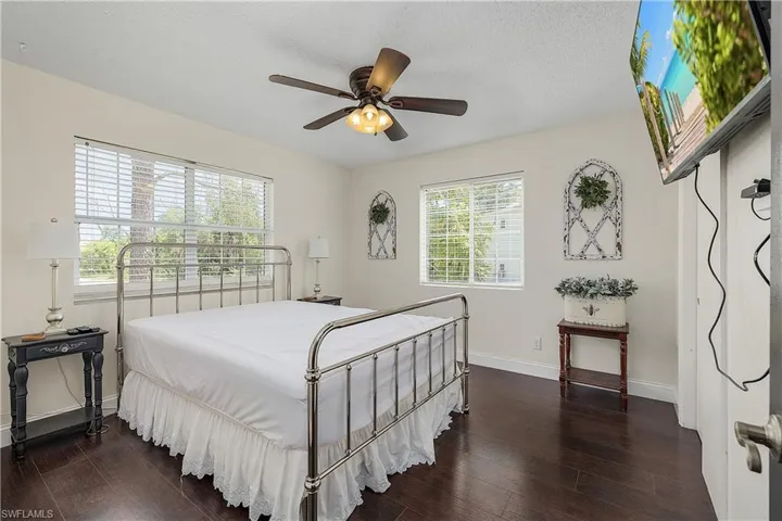 Bedroom featuring dark wood-type flooring, ceiling fan, and a textured ceiling
