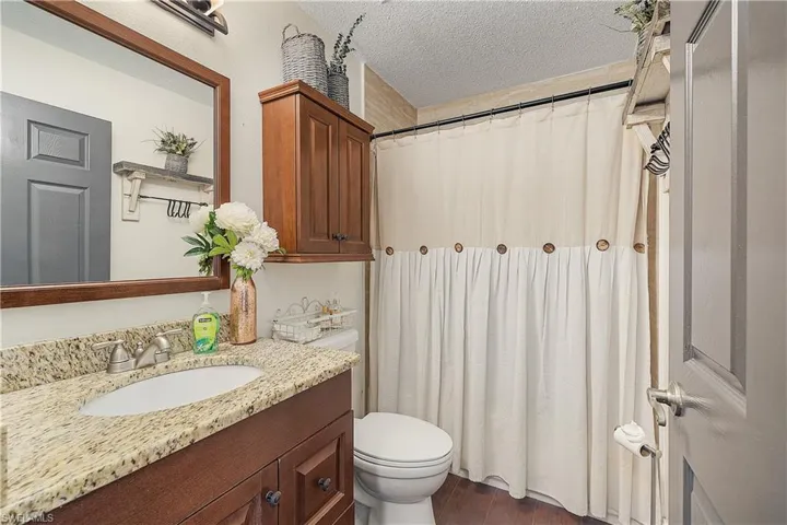 Bathroom featuring vanity, toilet, a textured ceiling, and hardwood / wood-style flooring