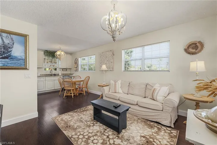 Living room featuring a chandelier, a textured ceiling, and dark hardwood / wood-style flooring
