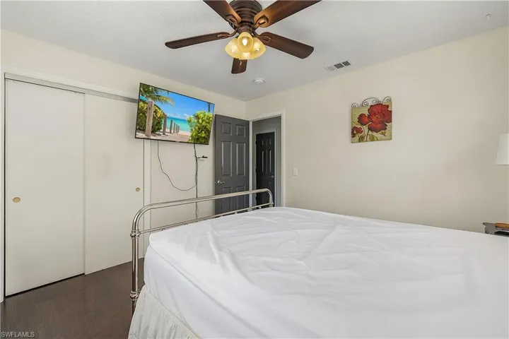 Bedroom featuring a closet, ceiling fan, and dark hardwood / wood-style flooring