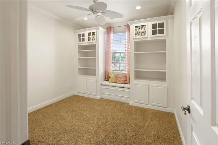 Third bedroom with custom built-in bookshelves and window seat