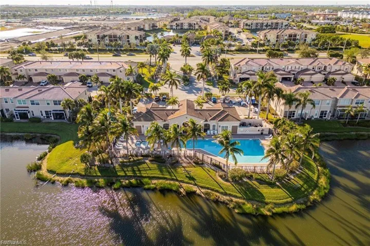 Aerial perspective of suburban area featuring a large body of water and a pool area