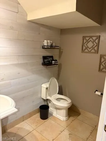 Bathroom with toilet and light tile floors