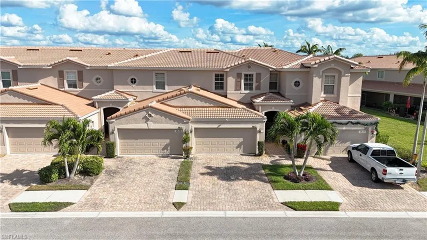Mediterranean / spanish house featuring a residential view, stucco siding, a tiled roof, and decorative driveway