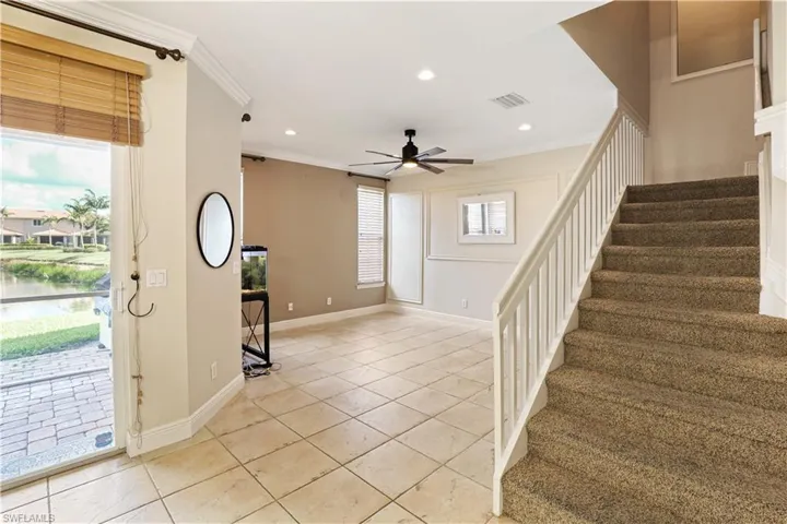Foyer entrance with stairs, light tile patterned flooring, ornamental molding, recessed lighting, and ceiling fan