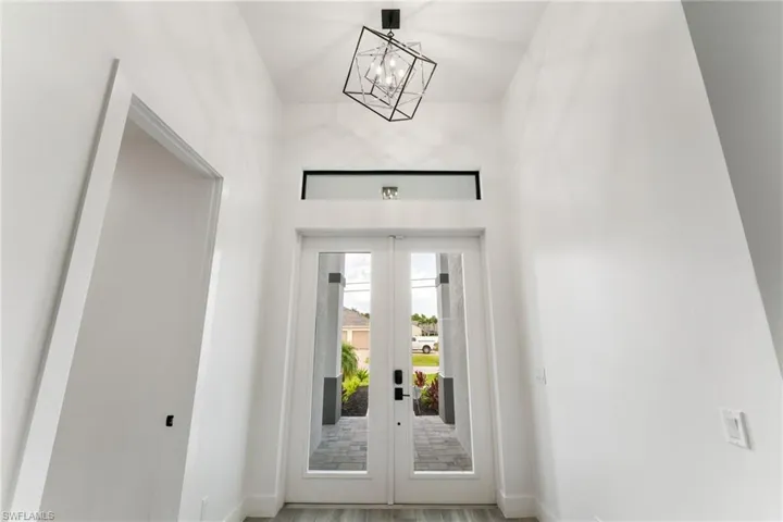 Foyer entrance featuring french doors, a chandelier with 12.8ft ceiling