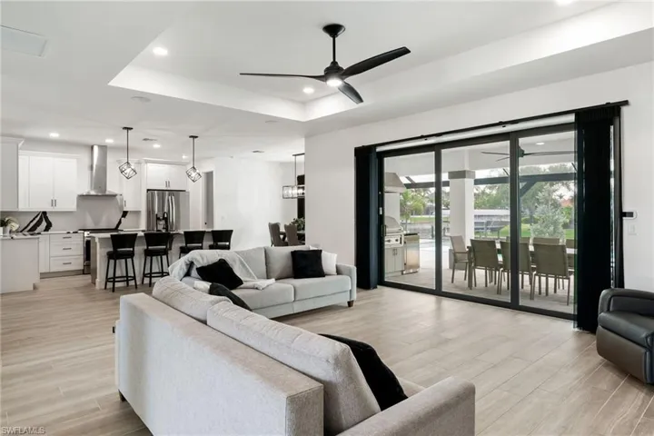 Living area featuring a tray ceiling, recessed lighting, tile floors with 10.2 ft ceilings