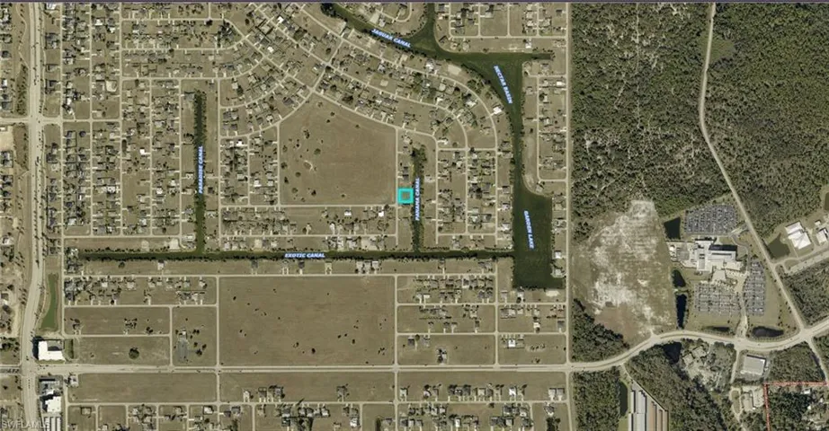 Aerial Map. An overhead view of a developed area and undeveloped land, with a highlighted parcel indicating the property