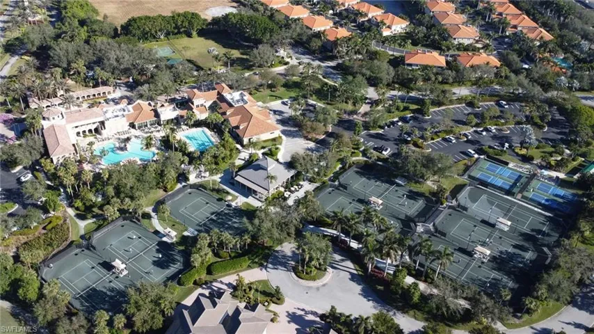 Aerial view of property and surrounding area featuring nearby suburban area and a pool