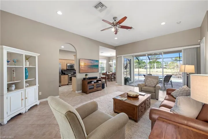 Living area featuring light tile patterned floors, a ceiling fan, a sunroom, and recessed lighting