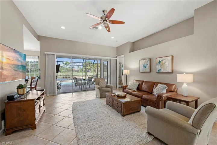 Living room featuring a sunroom, a ceiling fan, healthy amount of natural light, light tile patterned floors, and recessed lighting