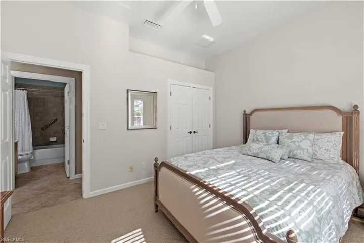 Bedroom featuring light carpet, a closet, a ceiling fan, and light tile patterned flooring