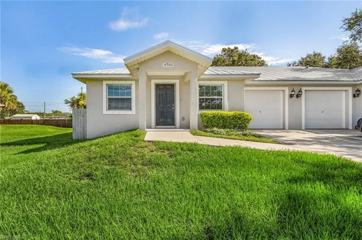 View of front of home featuring stucco siding, a metal roof, a garage, and concrete driveway