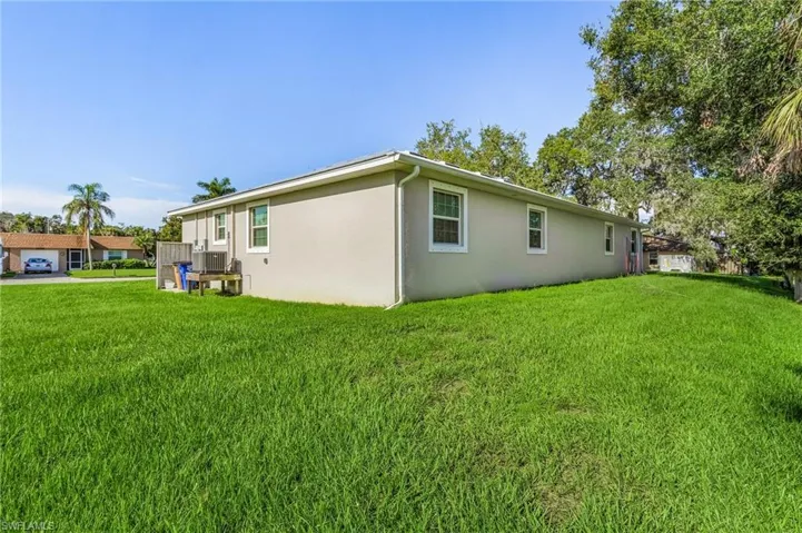 View of side of home with a yard and stucco siding