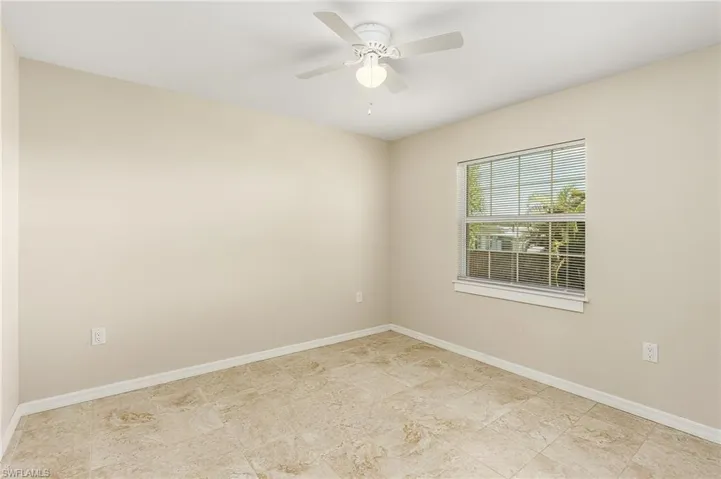 Spare room featuring baseboards and ceiling fan