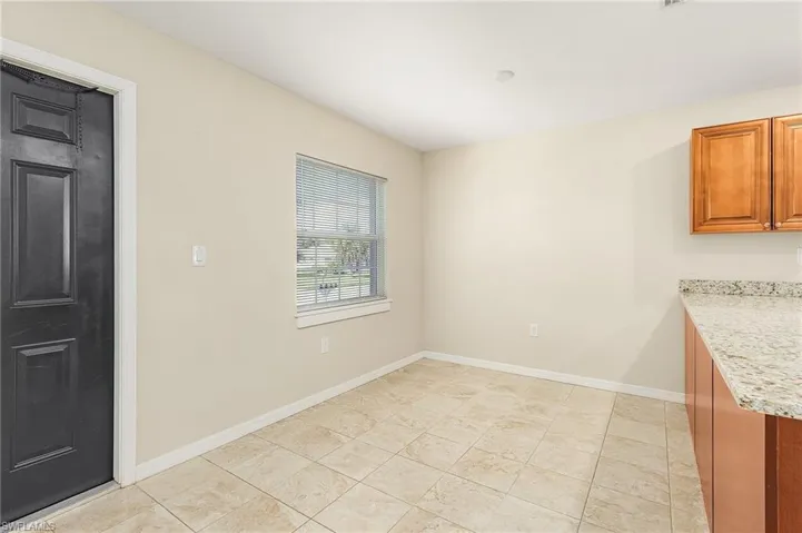 Unfurnished dining area with baseboards and light tile patterned flooring
