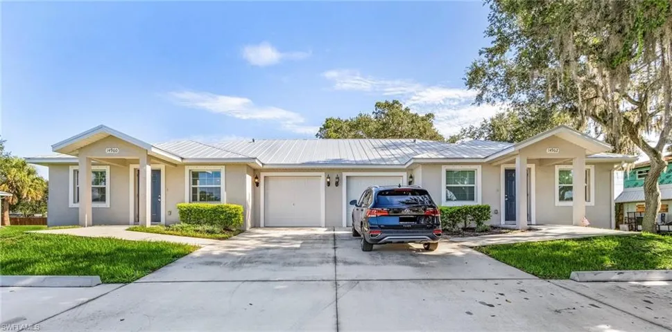 Ranch-style home with stucco siding, driveway, and a front lawn