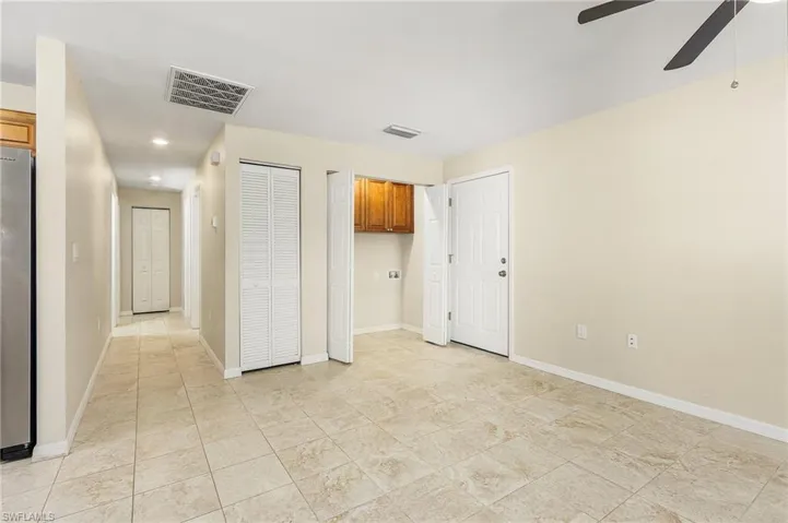 Unfurnished bedroom featuring freestanding refrigerator, a ceiling fan, recessed lighting, and two closets