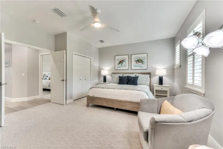 Bedroom featuring ceiling fan, a closet, and light carpet