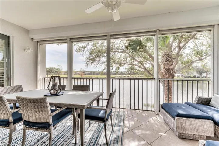 Sunroom / solarium featuring ceiling fan and a water view