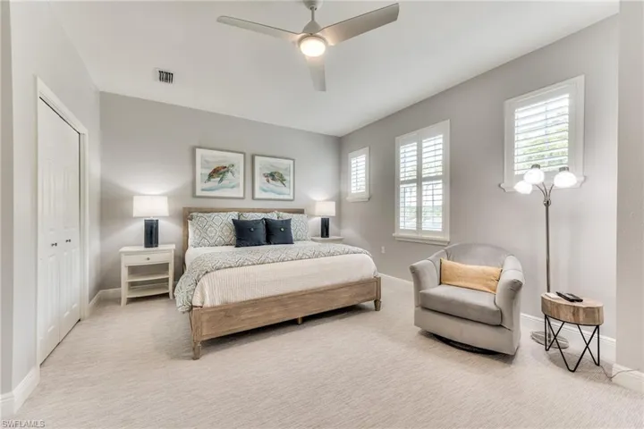 Bedroom featuring a closet, light colored carpet, and ceiling fan