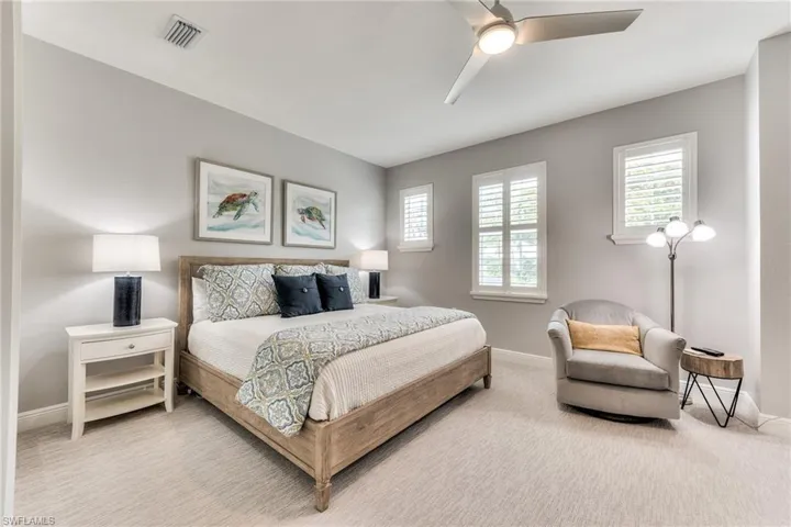 Bedroom with ceiling fan, carpet floors, and multiple windows