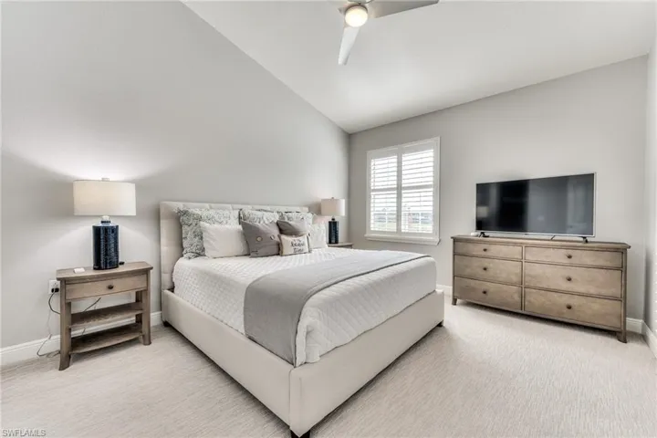 Bedroom featuring ceiling fan, carpet, and lofted ceiling
