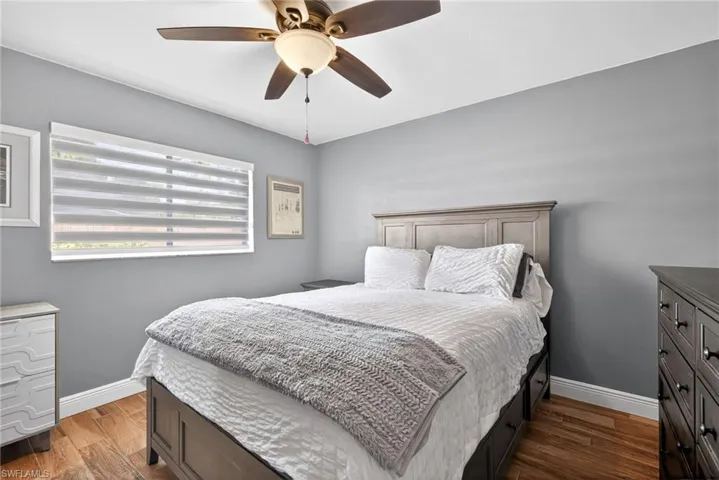 Bedroom with dark wood-type flooring and a ceiling fan