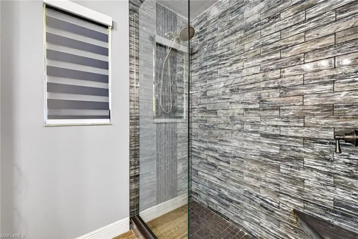 Bathroom featuring a walk in shower and baseboards