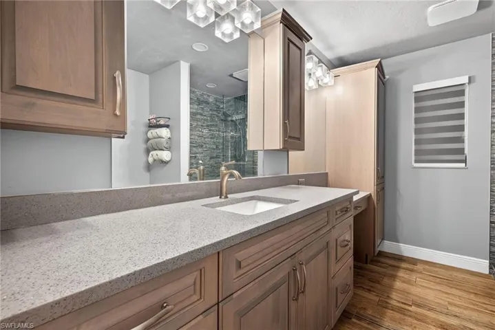 Full bath featuring vanity, a shower stall, and light wood-style flooring