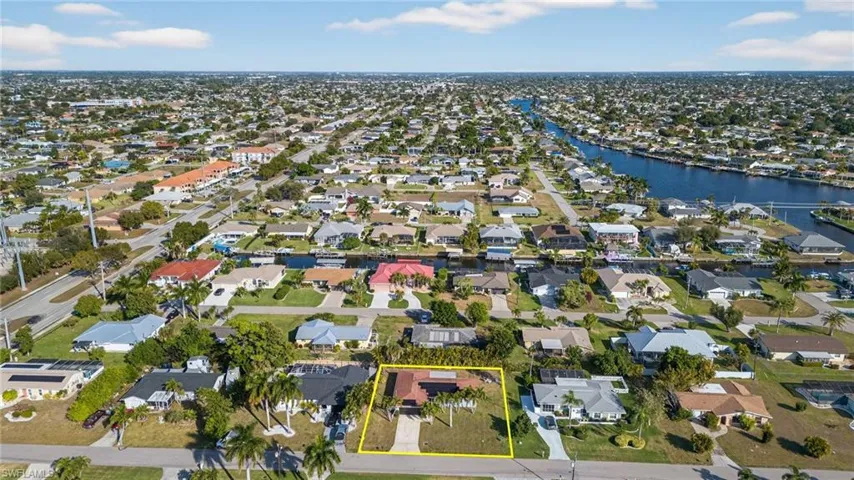 Aerial overview of property's location featuring nearby suburban area, property boundaries highlighted, and a nearby body of water
