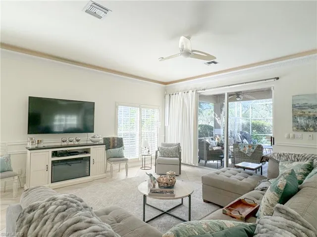 Tiled living room featuring crown molding and ceiling fan