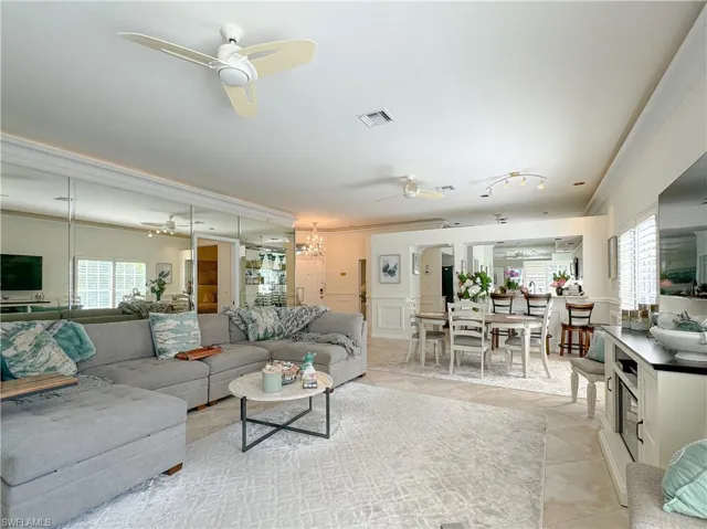 Living room with plenty of natural light, ceiling fan, crown molding, and light tile floors