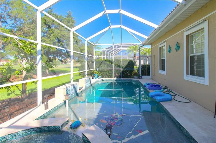 View of swimming pool featuring a patio, a lanai, and a lawn