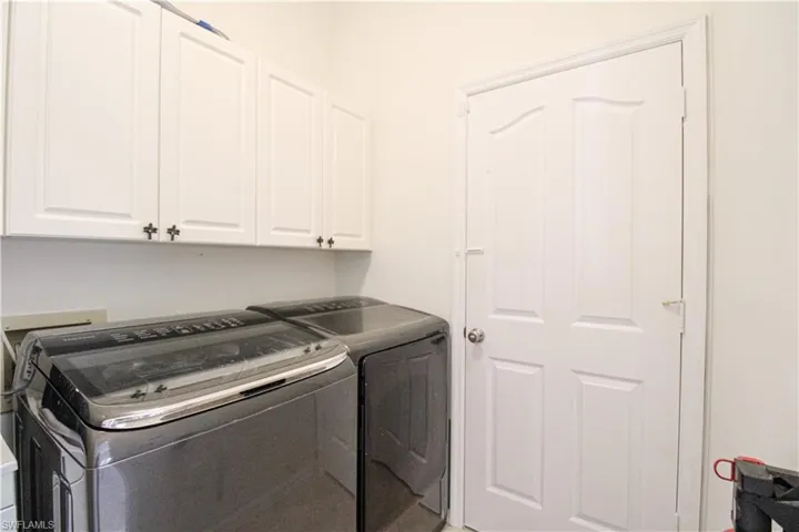 Laundry room with washer and dryer and cabinets