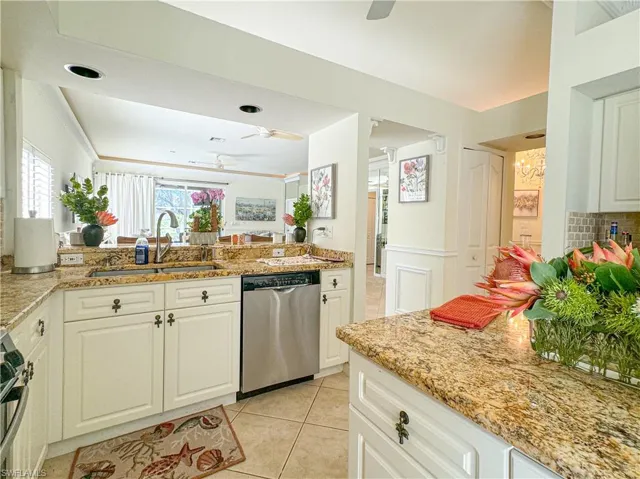 Kitchen with white cabinetry, appliances with stainless steel finishes, sink, ceiling fan, and light tile floors